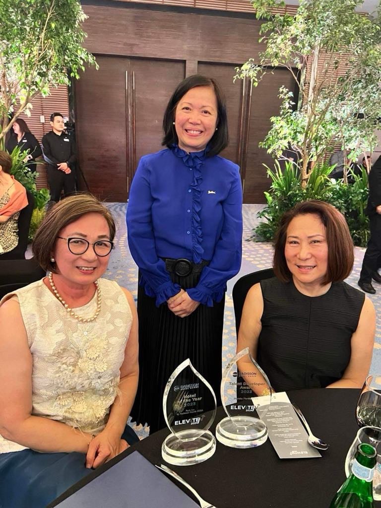 the hotelier flanked by SMHCC chair and president Elizabeth Sy (seated right) and executive vice president Peggy Angeles.